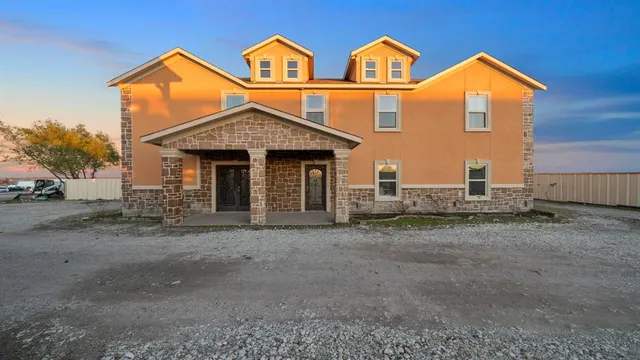 a kitchen with a table chairs refrigerator and microwave