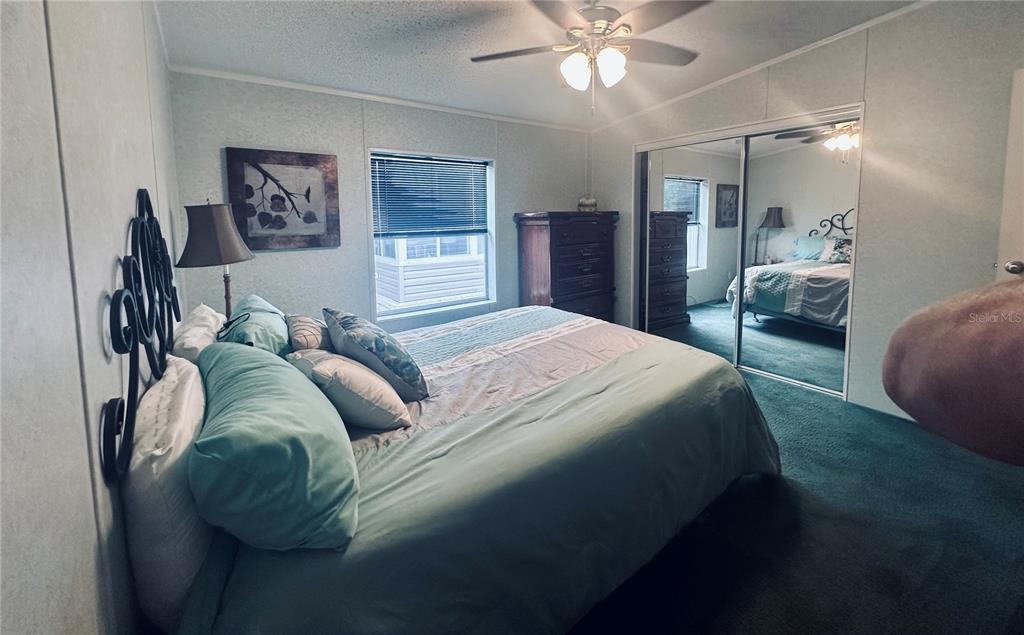 1100 South Belcher Road, Unit 406 Largo, FL 33771 - Photo 16 of 46 a bedroom with a bed and a chandelier
