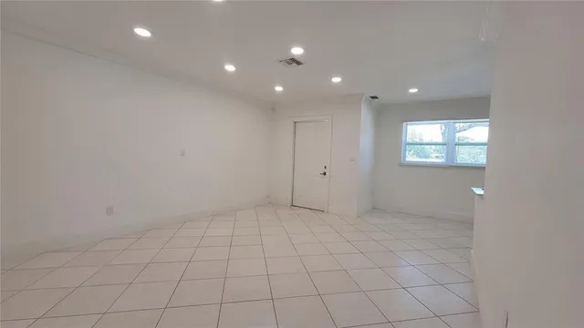 an empty room with white walls and windows