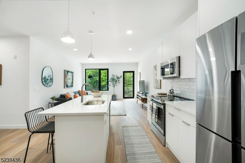 803 South Avenue, Unit 510 Plainfield, NJ 07062 - Photo 4 of 47 a kitchen with stainless steel appliances granite countertop a refrigerator a sink dishwasher a stove with white cabinets and wooden floor