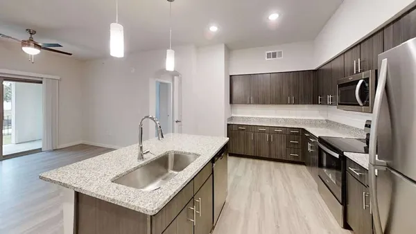 a kitchen with stainless steel appliances granite countertop a sink refrigerator and cabinets