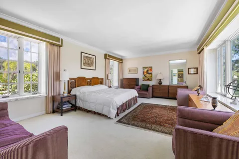 a bedroom with furniture and a large window