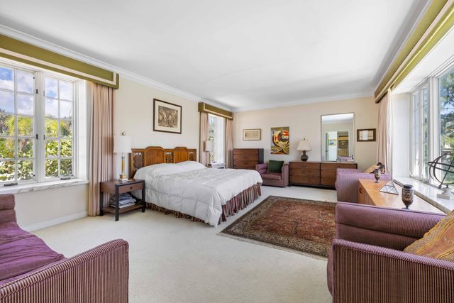 a bedroom with furniture and a large window