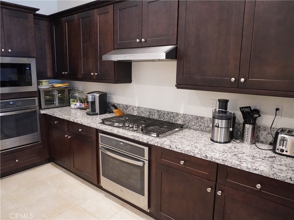 348 Scarlett Runner Beaumont, CA 92223 - Photo 20 of 33 a kitchen with granite countertop wood cabinets and stainless steel appliances