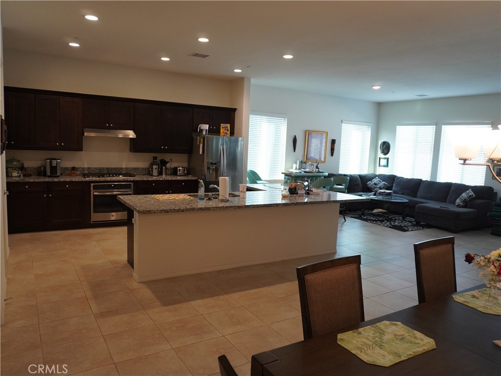 348 Scarlett Runner Beaumont, CA 92223 - Photo 4 of 33 a kitchen with stainless steel appliances granite countertop a sink a stove a refrigerator a counter top space and cabinets