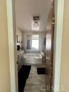 a bathroom with a granite countertop sink a mirror and a bathtub