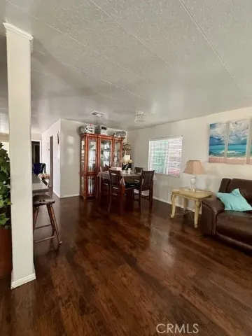 a living room with furniture and a dining table with kitchen view