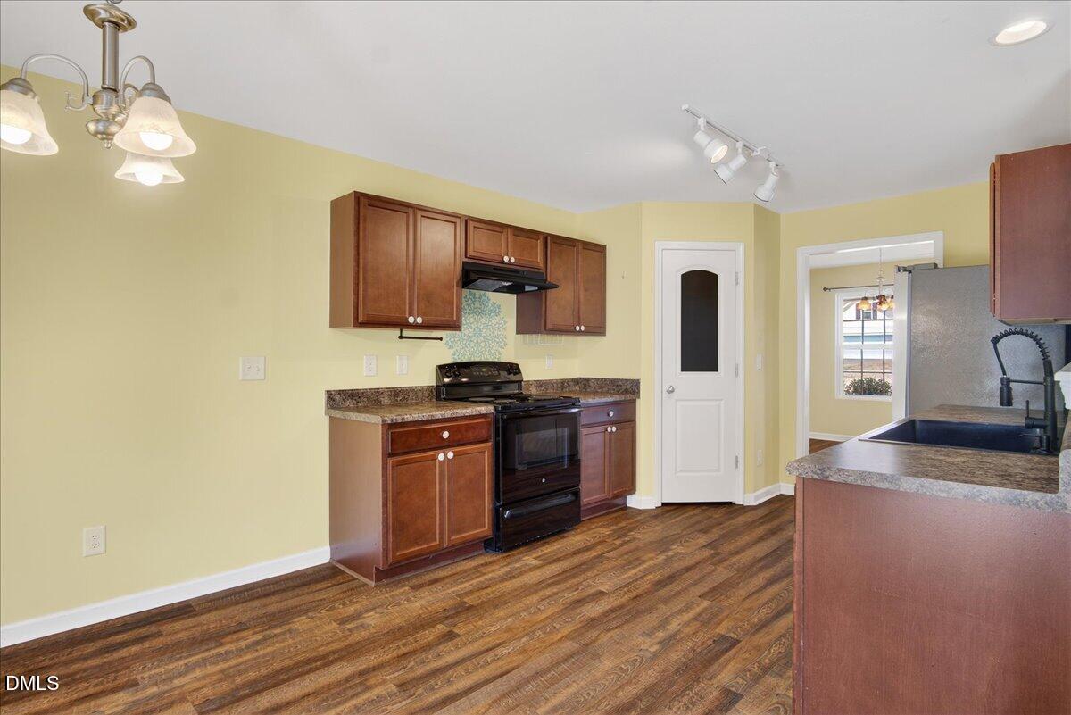 399 West Waycliff Road Henderson, NC 27537 - Photo 12 of 69 a kitchen with stainless steel appliances granite countertop a sink cabinets and wooden floor