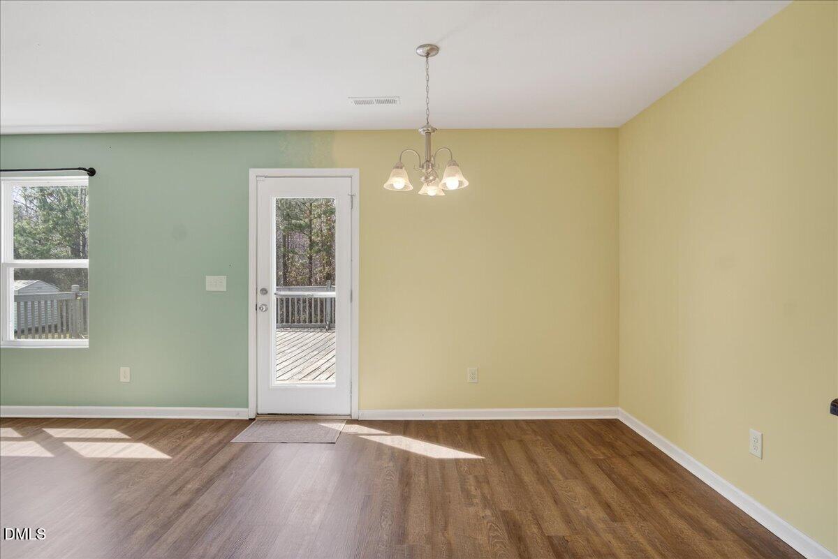 399 West Waycliff Road Henderson, NC 27537 - Photo 14 of 69 an empty room with wooden floor and windows