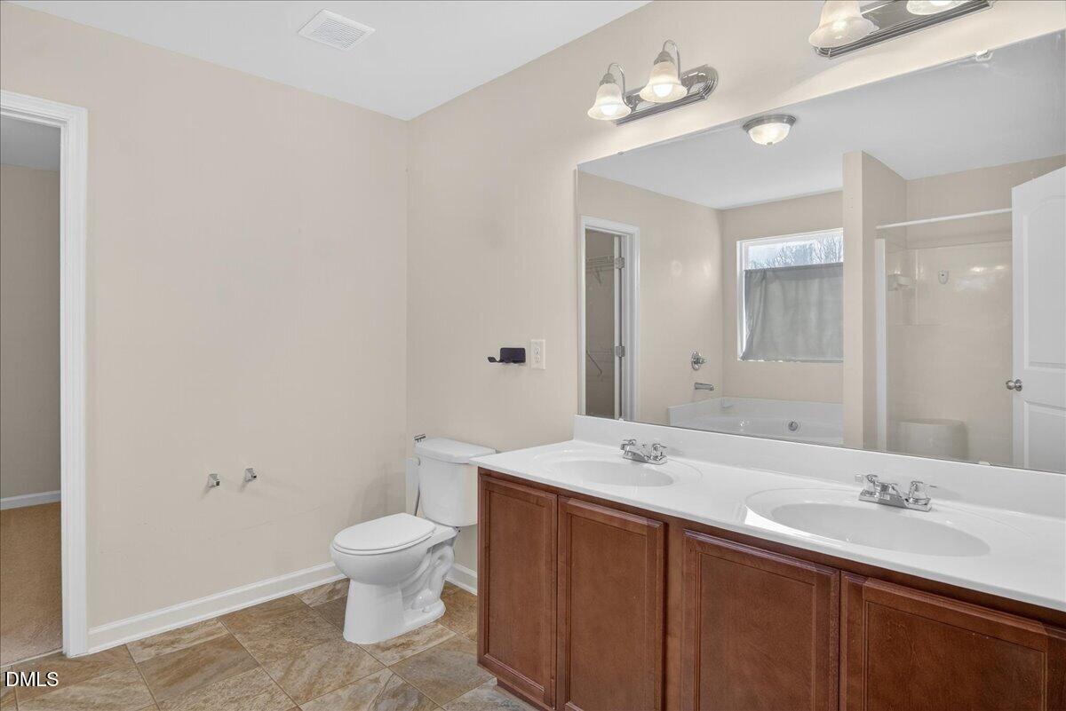 399 West Waycliff Road Henderson, NC 27537 - Photo 31 of 69 a bathroom with a double vanity sink mirror and toilet