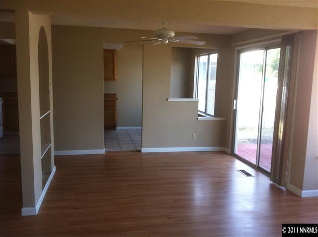 6199 Walnut Creek Road Reno, NV 89523 - Photo 3 of 6 an empty room with wooden floor and windows