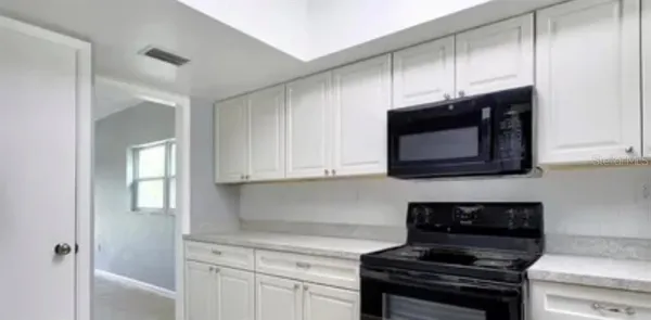 a kitchen with stainless steel appliances a stove a microwave and cabinets