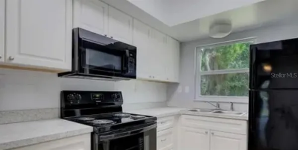 a kitchen with a stove microwave and sink