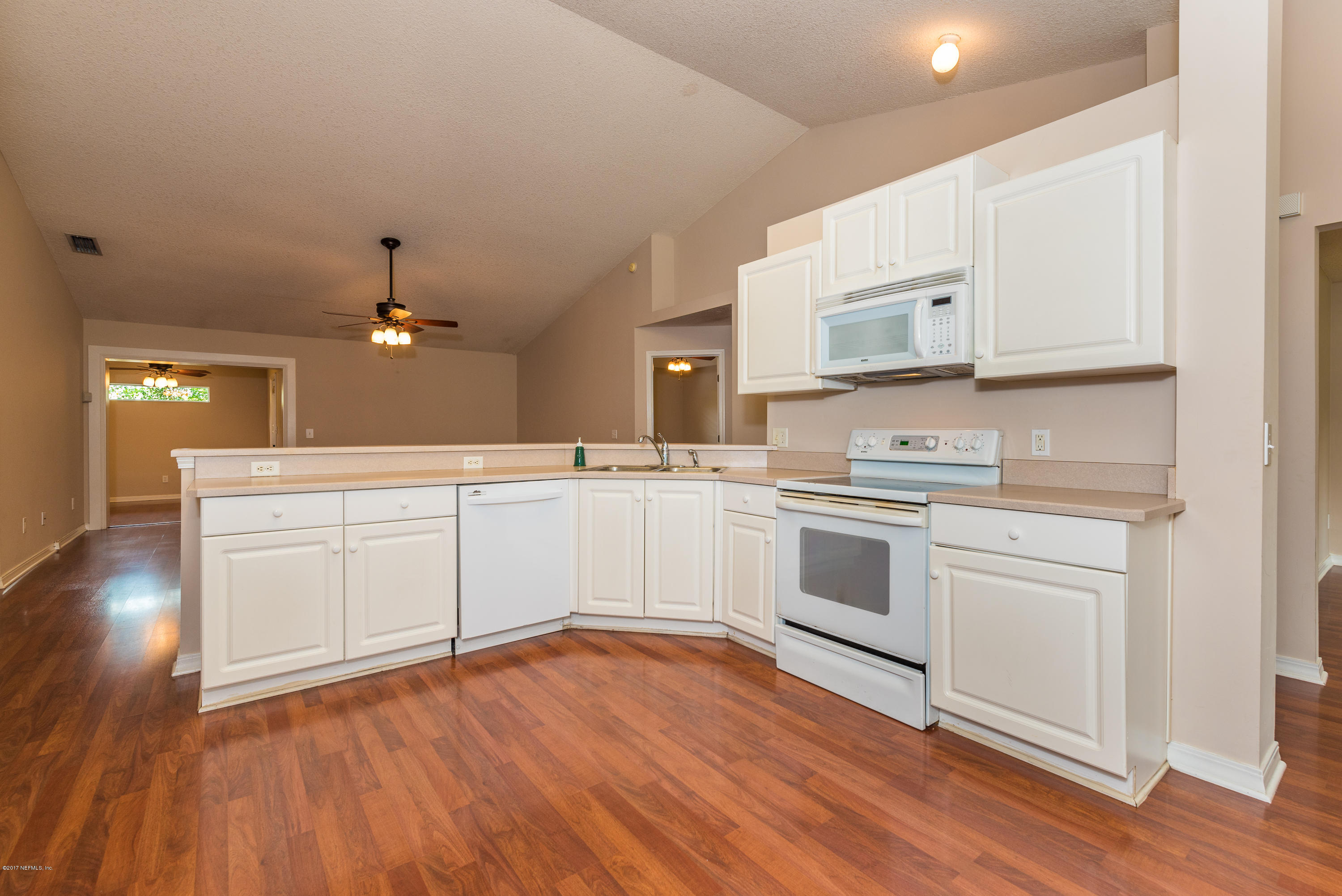444 Orchis Road St. Augustine, FL 32086 - Photo 16 of 56 a kitchen with a white cabinets and wooden floor
