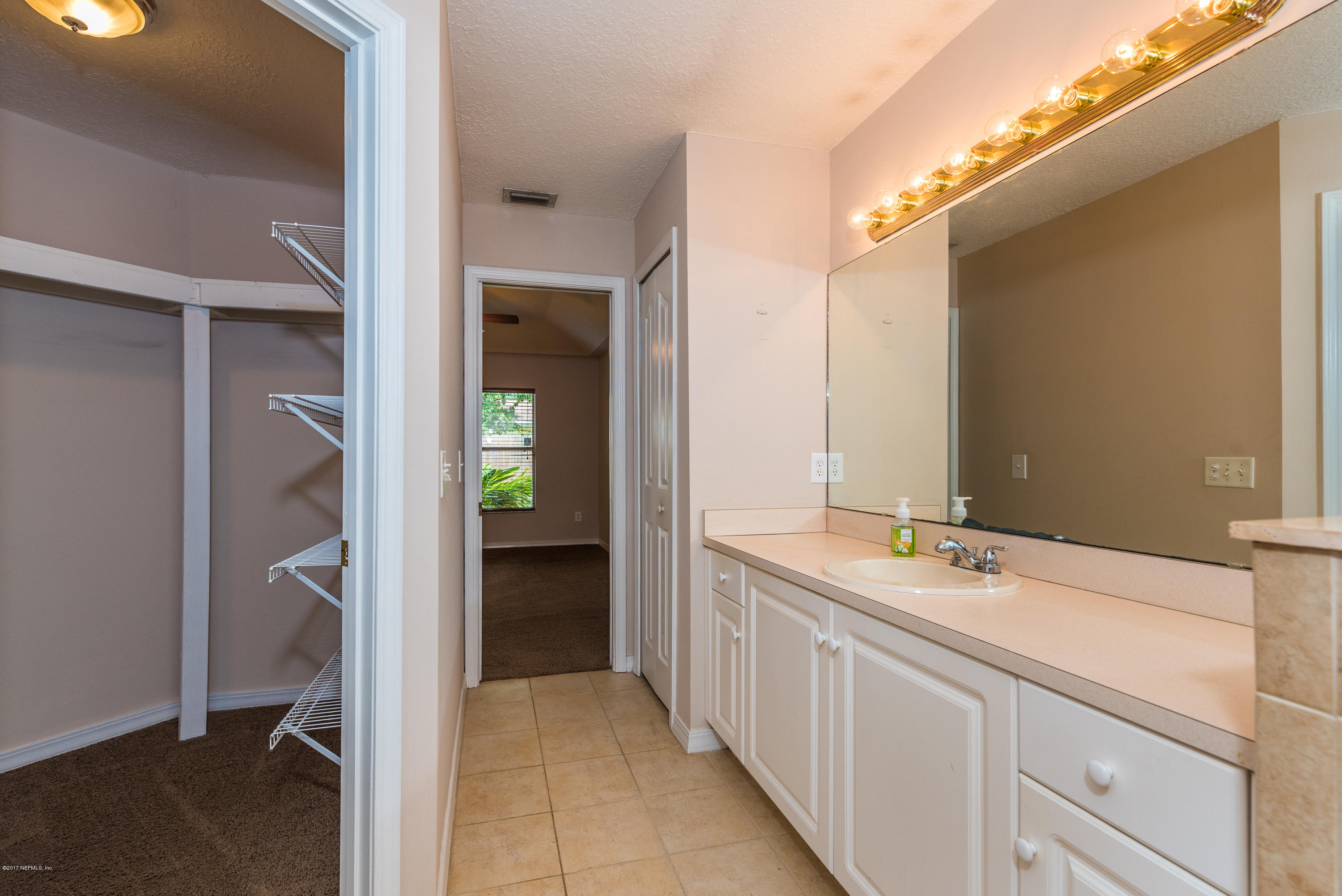 444 Orchis Road St. Augustine, FL 32086 - Photo 31 of 56 a en suite bathroom with a sink and mirror