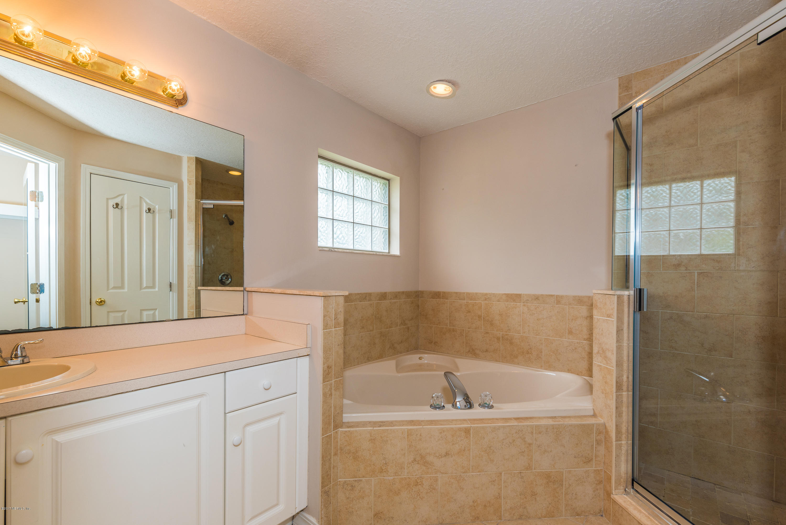 444 Orchis Road St. Augustine, FL 32086 - Photo 32 of 56 a bathroom with a bathtub sink and mirror