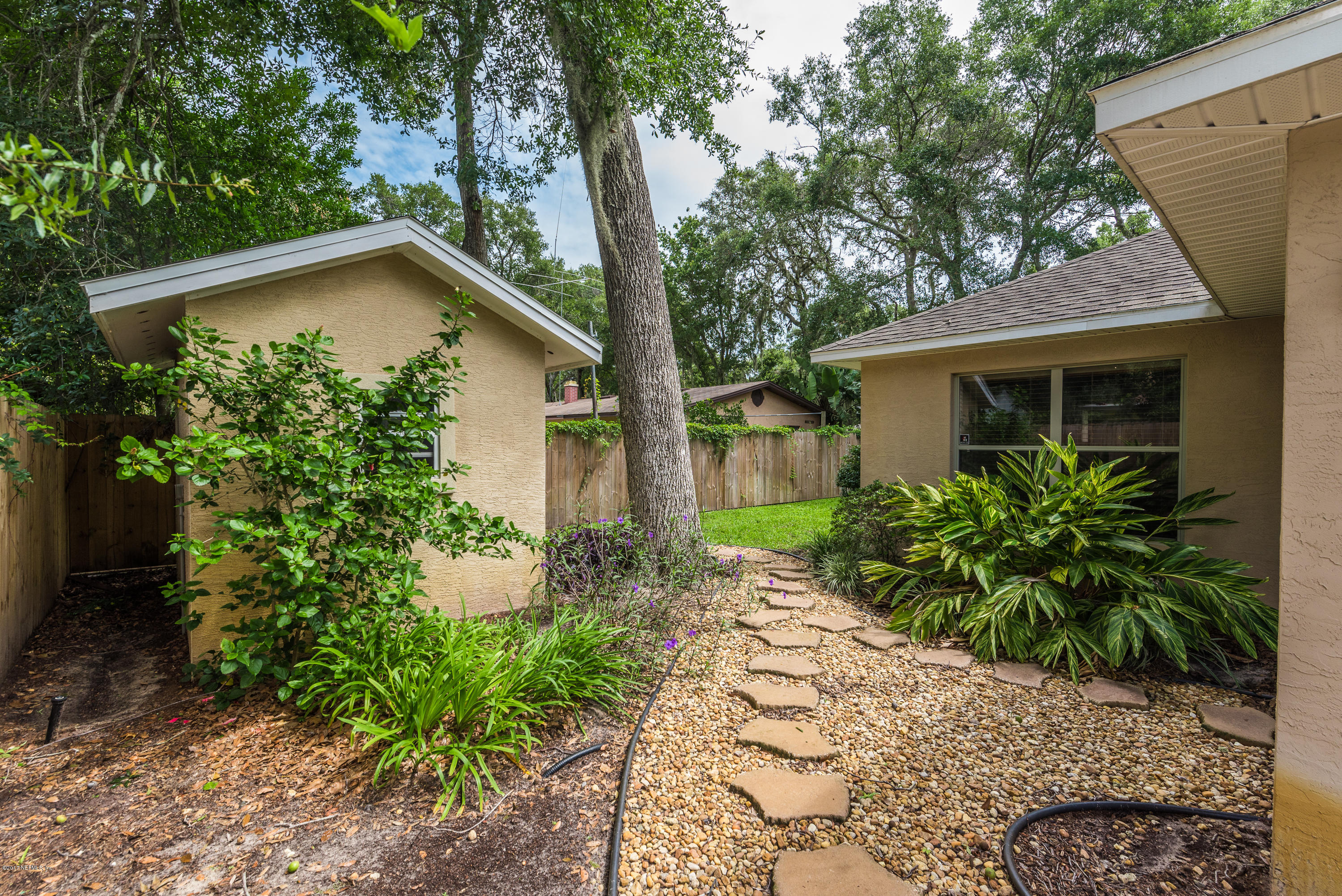 444 Orchis Road St. Augustine, FL 32086 - Photo 39 of 56 a backyard of a house with potted plants and large tree
