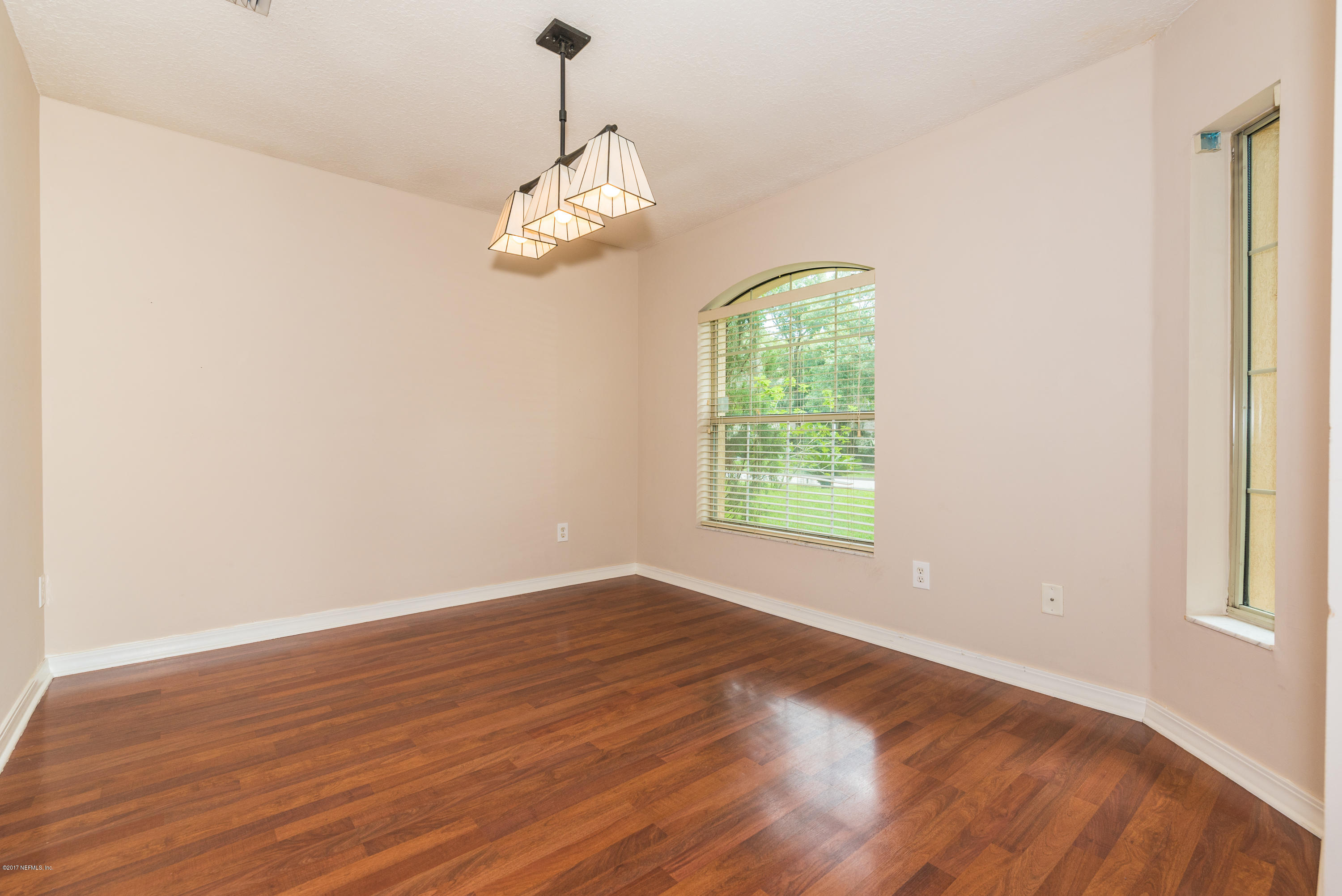 444 Orchis Road St. Augustine, FL 32086 - Photo 10 of 56 an empty room with wooden floor chandelier and windows
