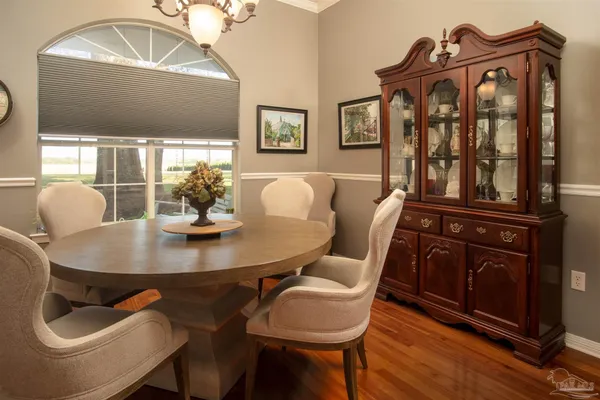 a dining room with furniture a chandelier and wooden floor