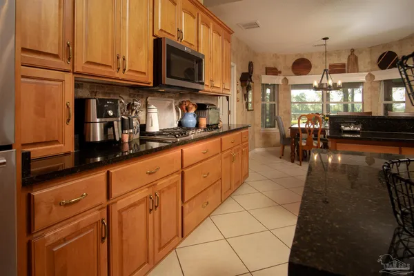 a kitchen with stainless steel appliances granite countertop a refrigerator a stove top oven a sink and dishwasher