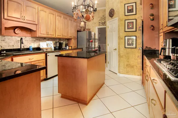 a kitchen with stainless steel appliances granite countertop a stove a sink and a refrigerator