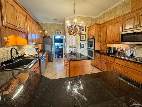 a kitchen with granite countertop a stove top oven microwave and cabinets