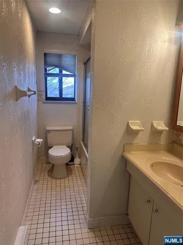 a bathroom with a toilet a sink and mirror