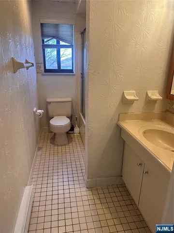 a bathroom with a sink a toilet and a mirror
