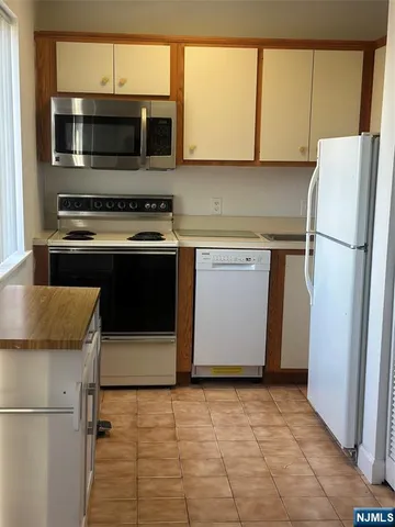 a kitchen with granite countertop a refrigerator and a stove