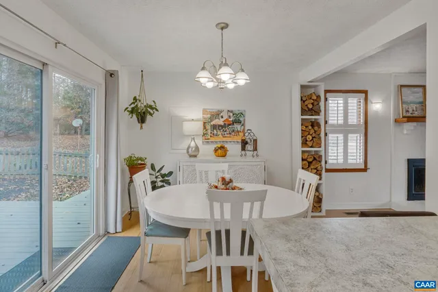 a view of a dining room with furniture a chandelier and wooden floor