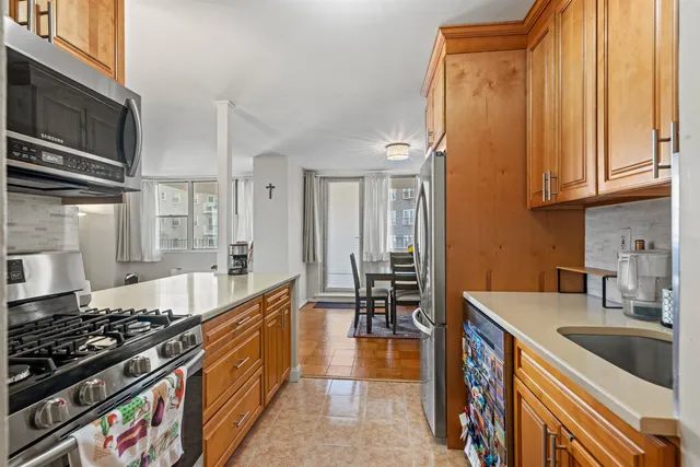 a kitchen with stainless steel appliances granite countertop a stove a sink and a microwave