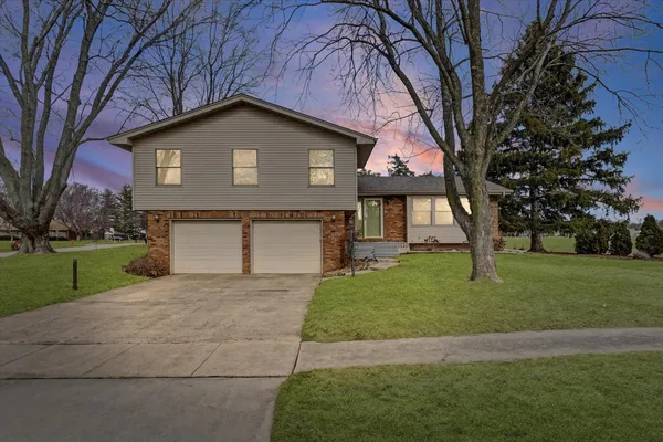 a front view of a house with a yard and garage
