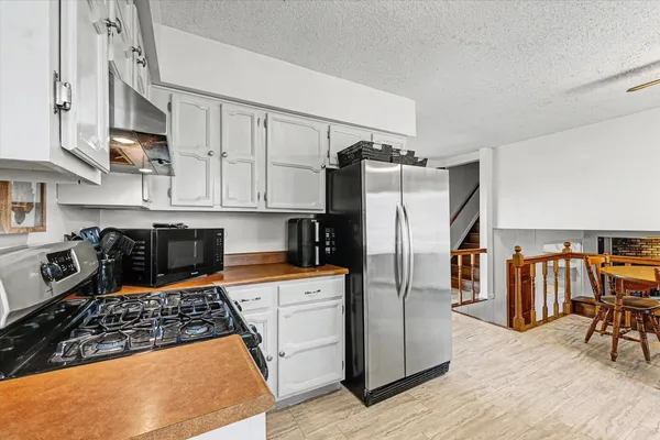 a kitchen with white cabinets and stainless steel appliances