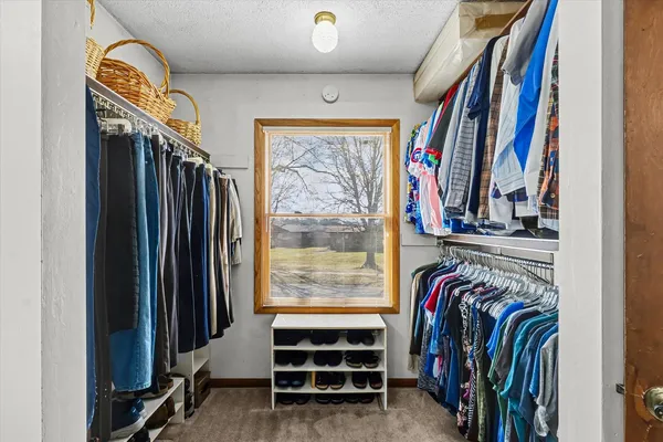 a view of walk in closet with clothes and shoes