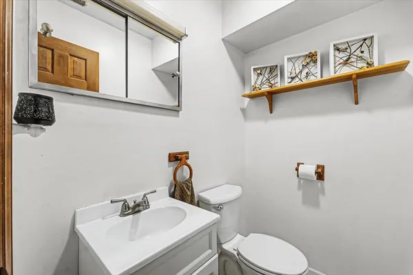 a bathroom with a sink mirror and toilet