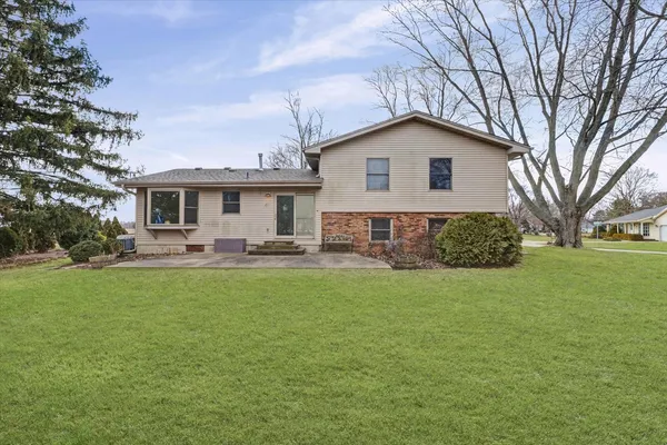 a view of a house with a yard and sitting area