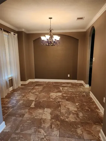 a view of a livingroom with a chandelier fan and windows
