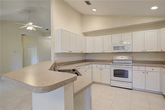 a kitchen with white cabinets and white appliances