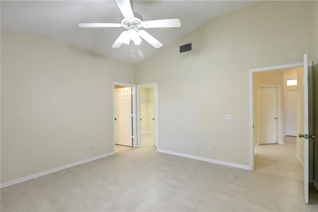 an empty room with a chandelier fan