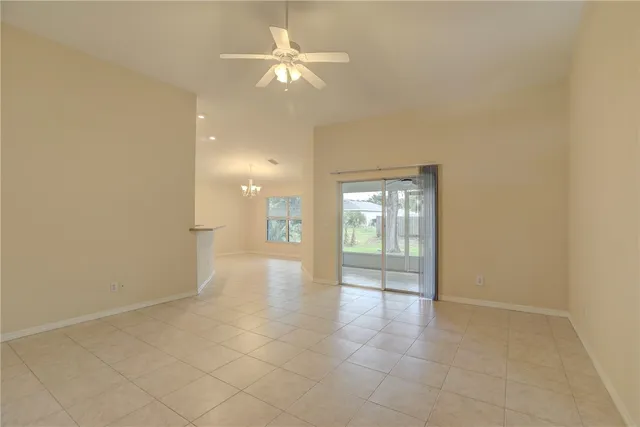 an empty room with chandelier fan