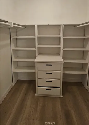 an empty room with wooden floor and cabinet