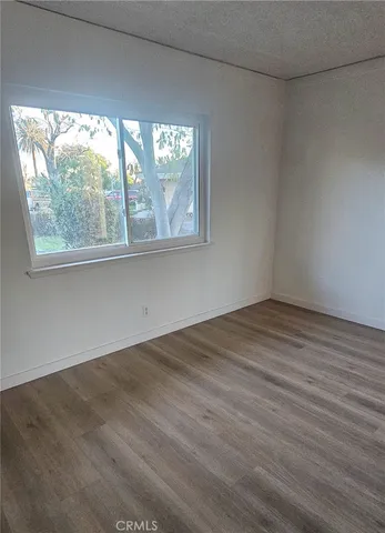 a view of an empty room with cabinet and a window