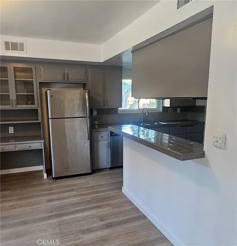 a view of kitchen with wooden floor and electronic appliances