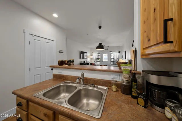 a kitchen with a sink a stove and a refrigerator with wooden floor