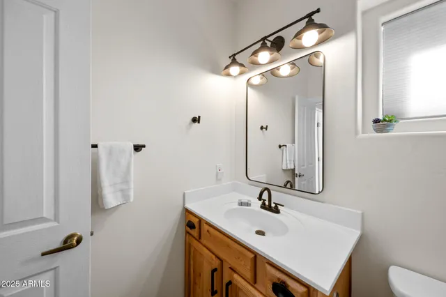 a bathroom with a sink a toilet a mirror and shower