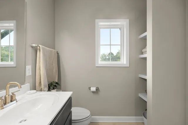 a bathroom with a sink toilet and window