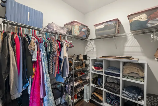 a view of walk in closet with clothes and shoes
