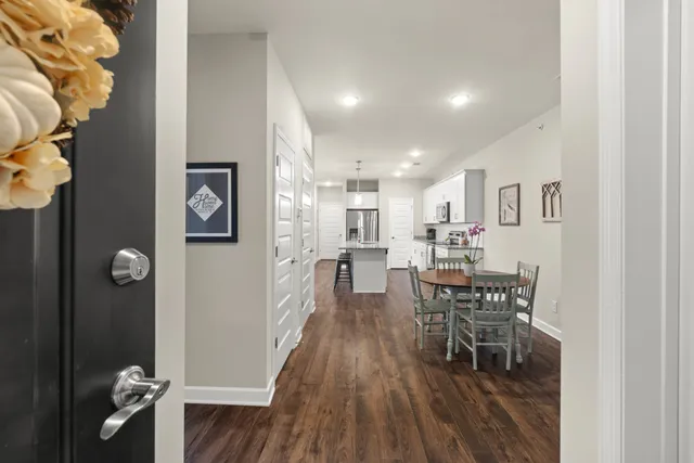 an open kitchen with dining table and wooden floor
