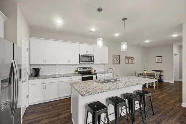 a kitchen with kitchen island granite countertop a sink a center island and cabinets