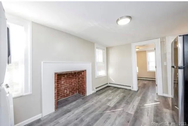 a view of empty room with wooden floor and fireplace